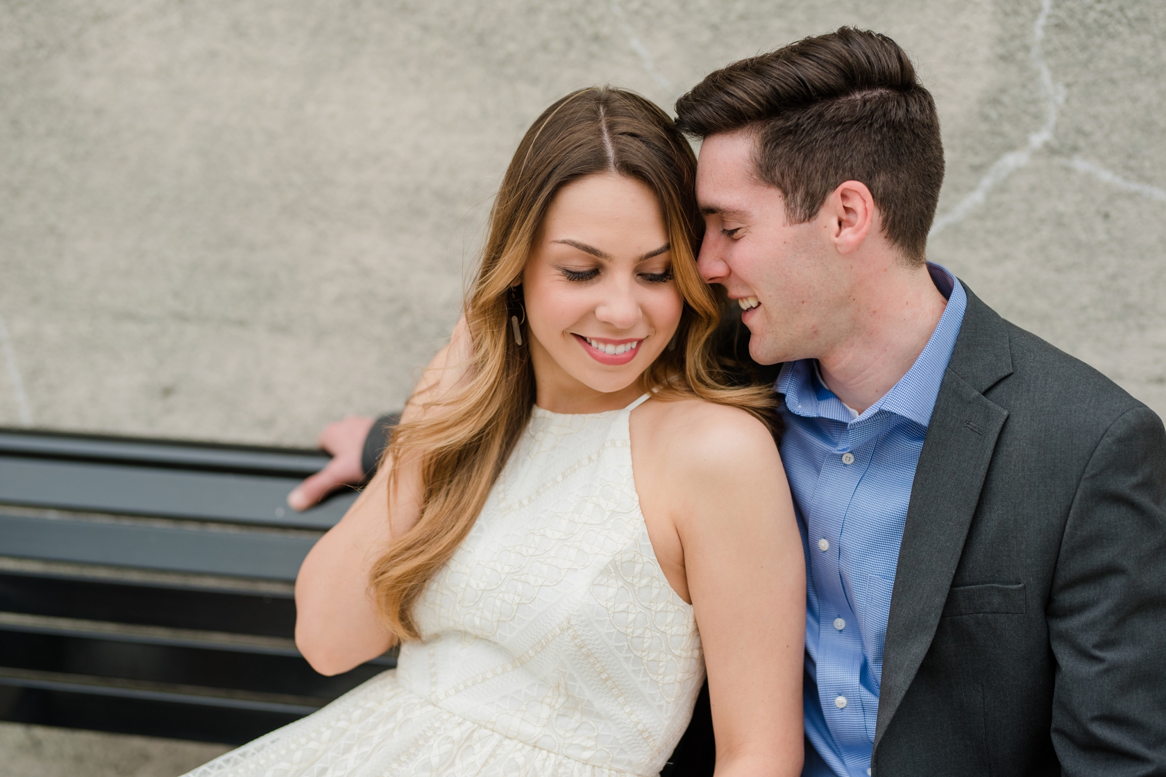 Young couple sitting on bench and cuddling